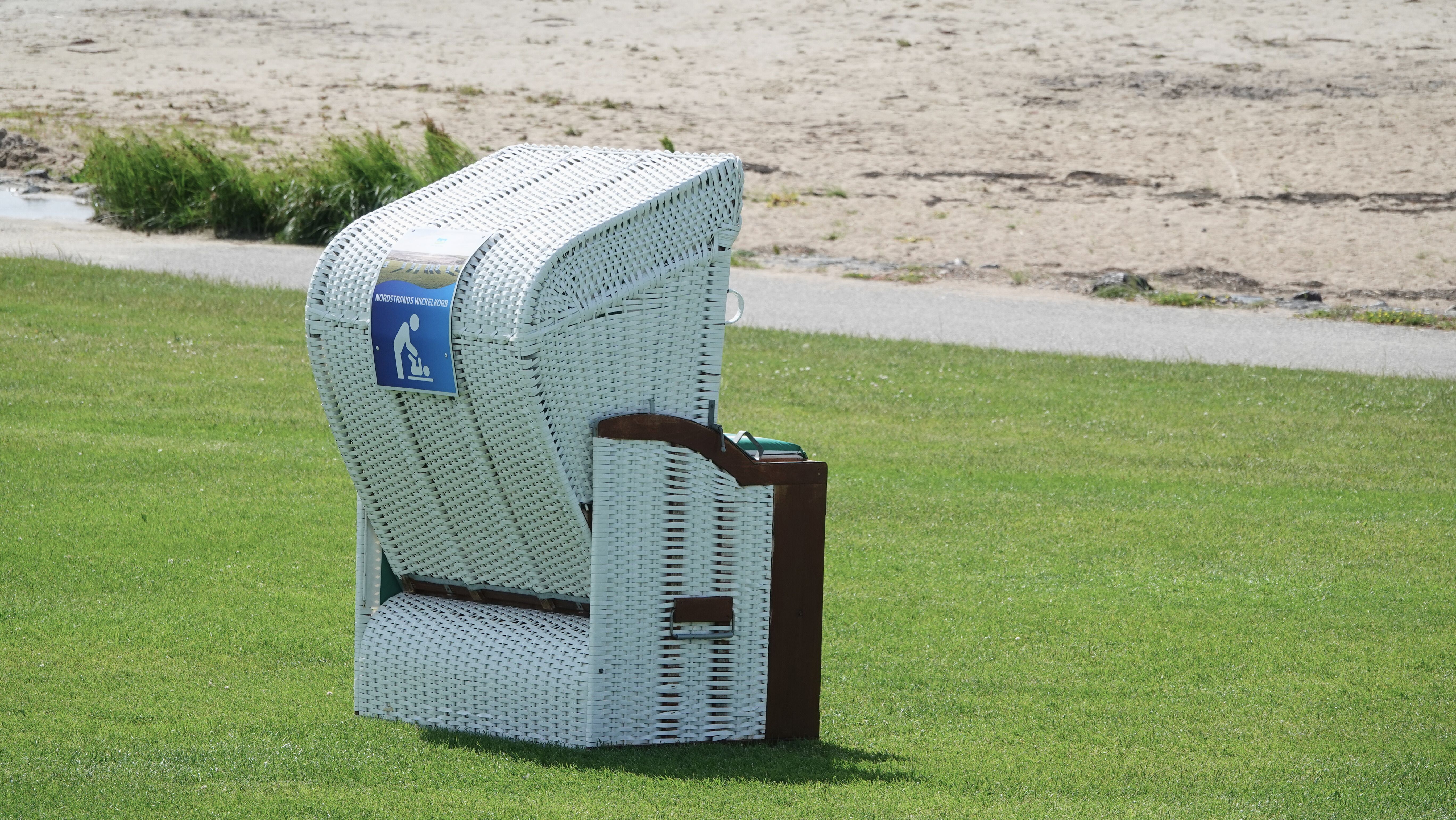 Ein Strandkorb am Deich mit Wickelsymbol