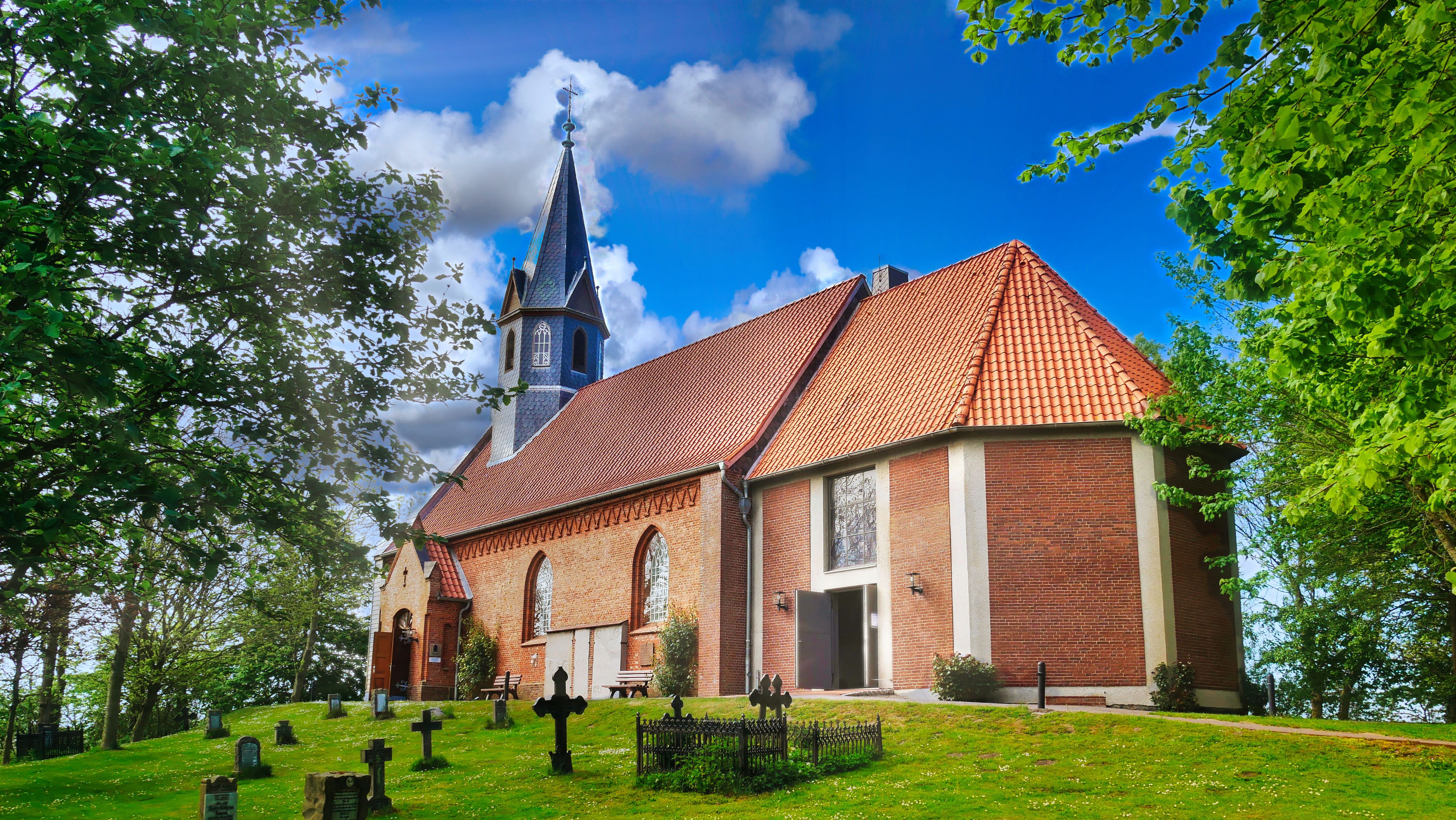 Ein Blick auf die evangelische Kirche in Odenbüll bei blauem Himmel. 