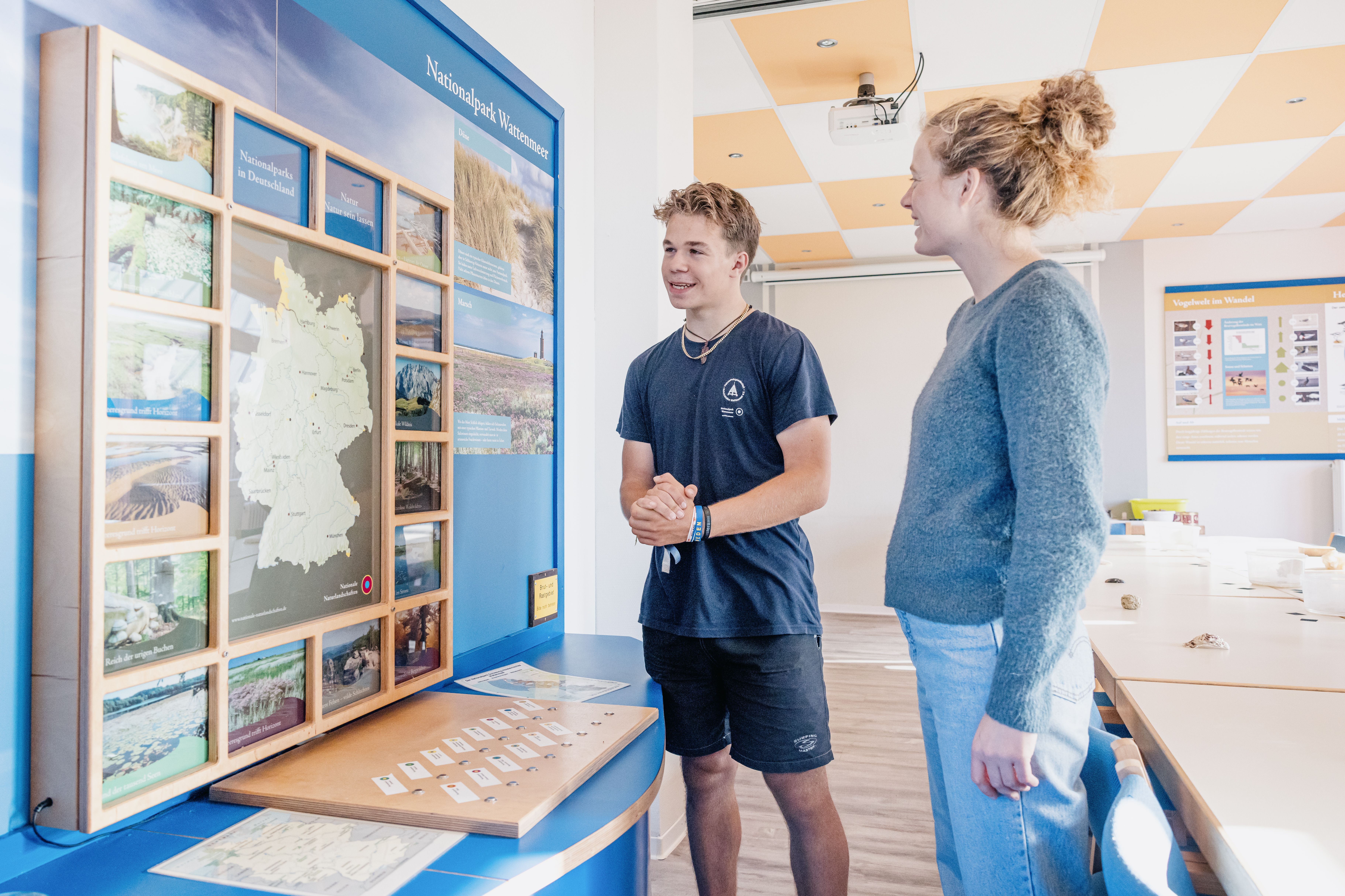 Ein Schutte führt einen Gast durch die Nationalpark Ausstellung. 