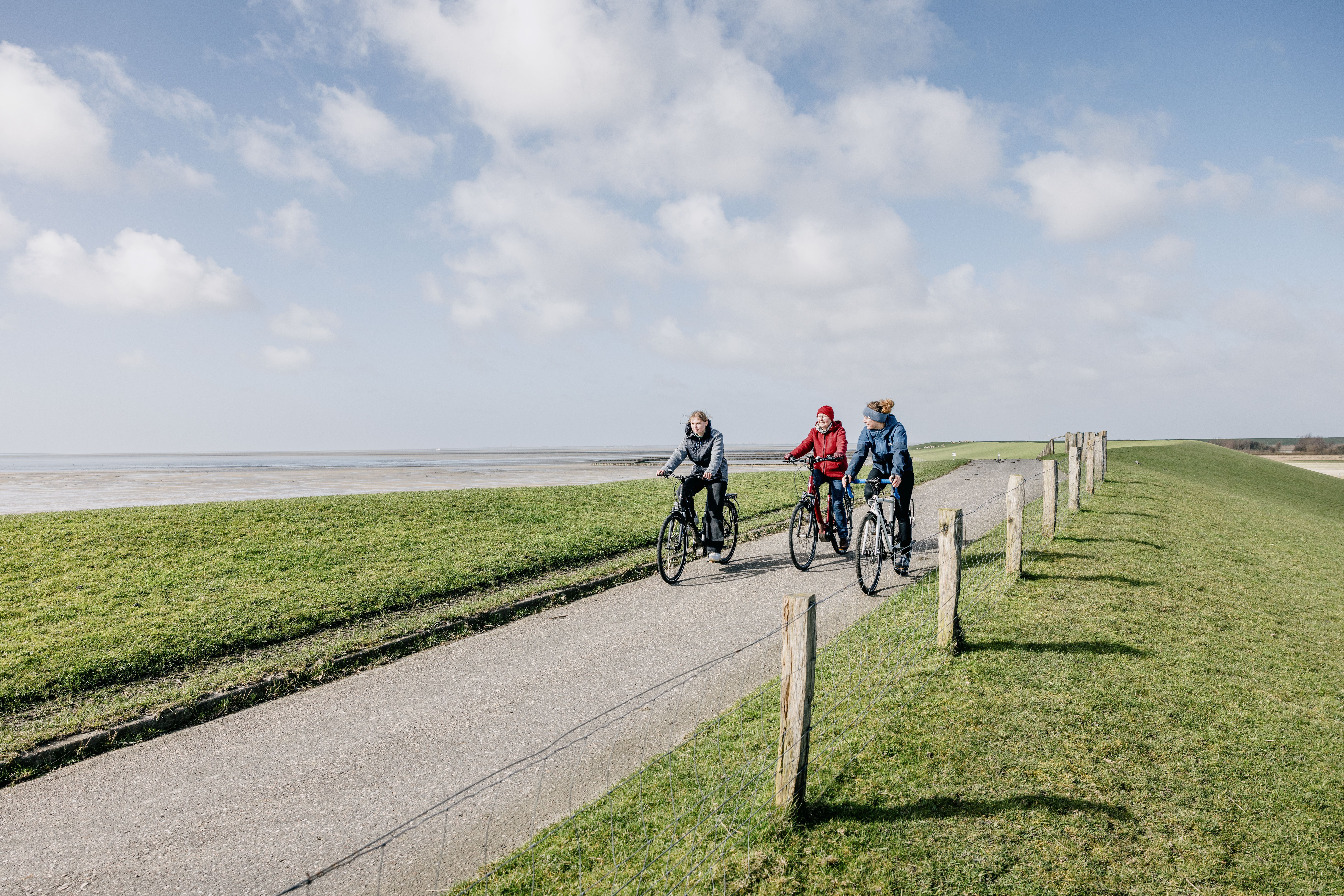 Drei Frauen fahren Fahrrad auf Nordstrand