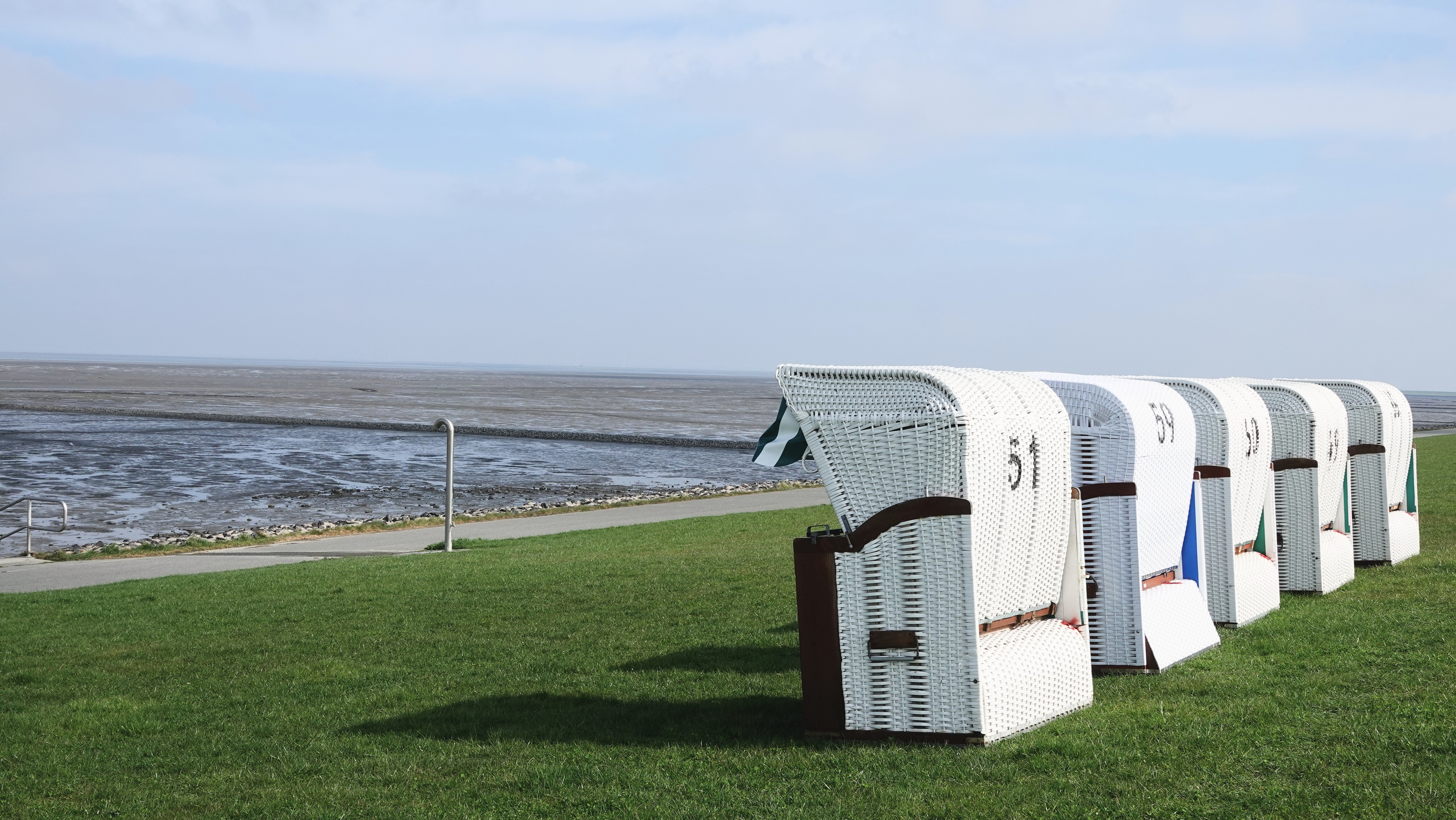 Strandkörbe am Deich mit Außendusche mit Blick aufs Watt