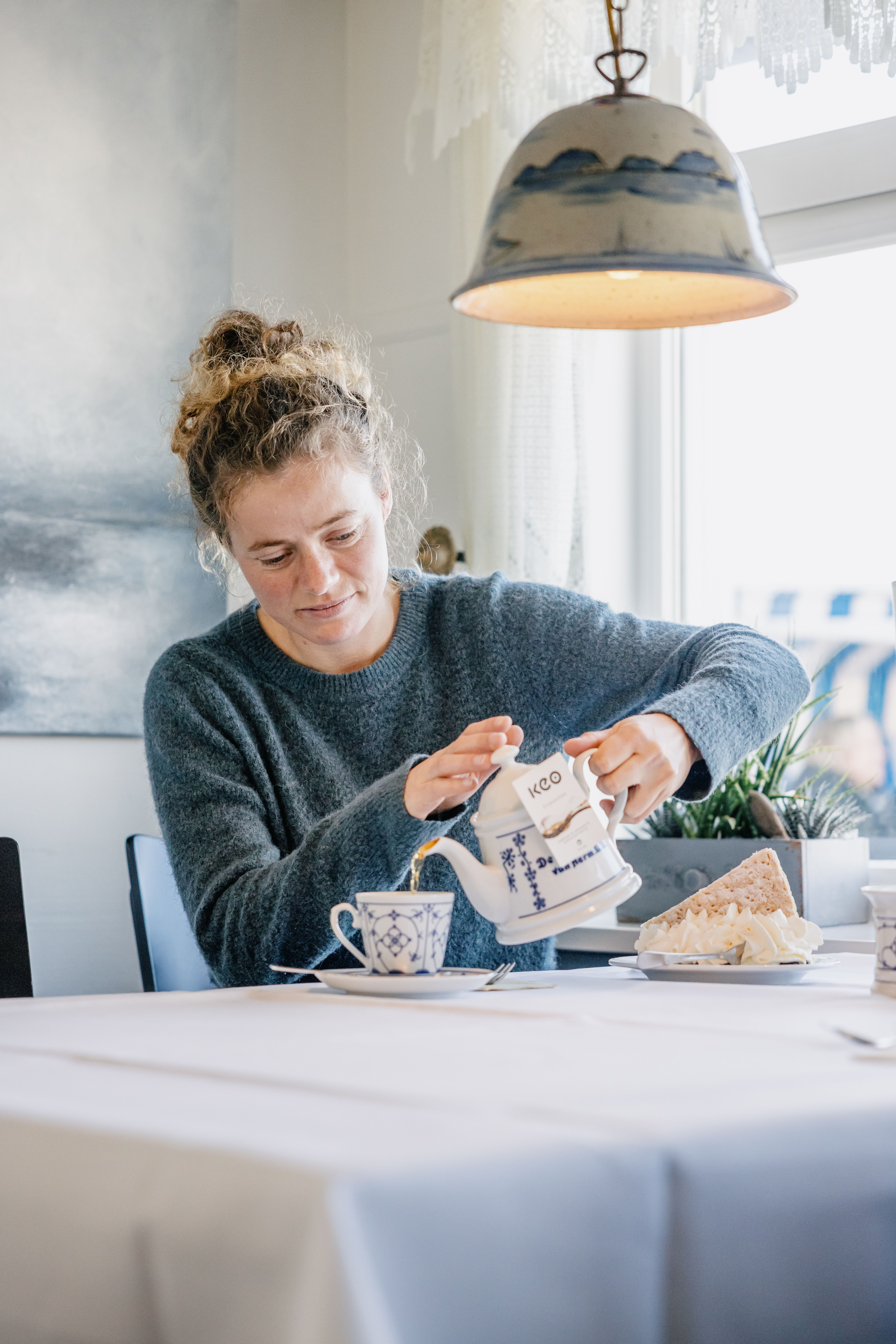Eine Frau schenkt sich Tee ein. 