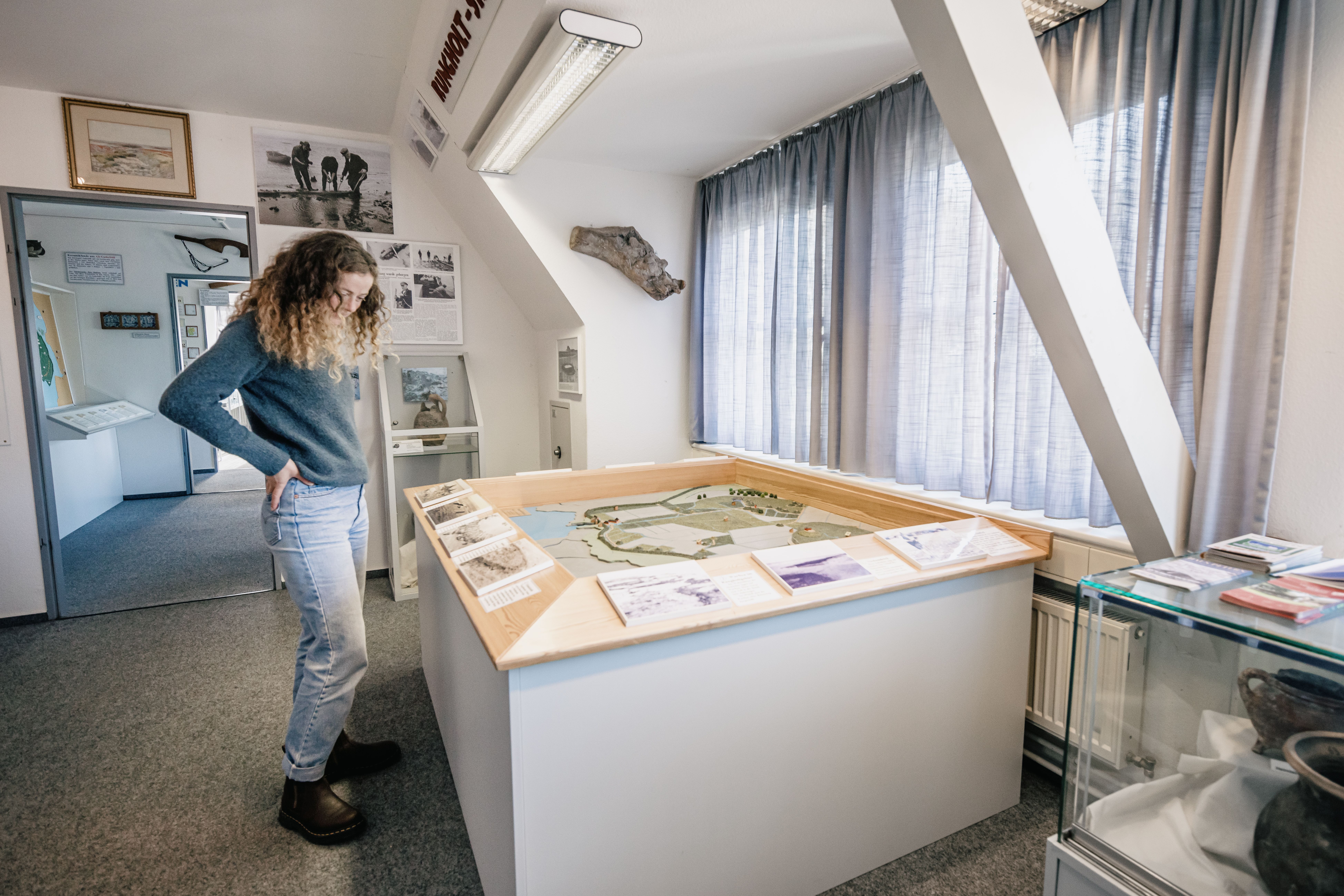 Eine Frau steht vor einem Modell von Nordstrand im Inselmuseum. 