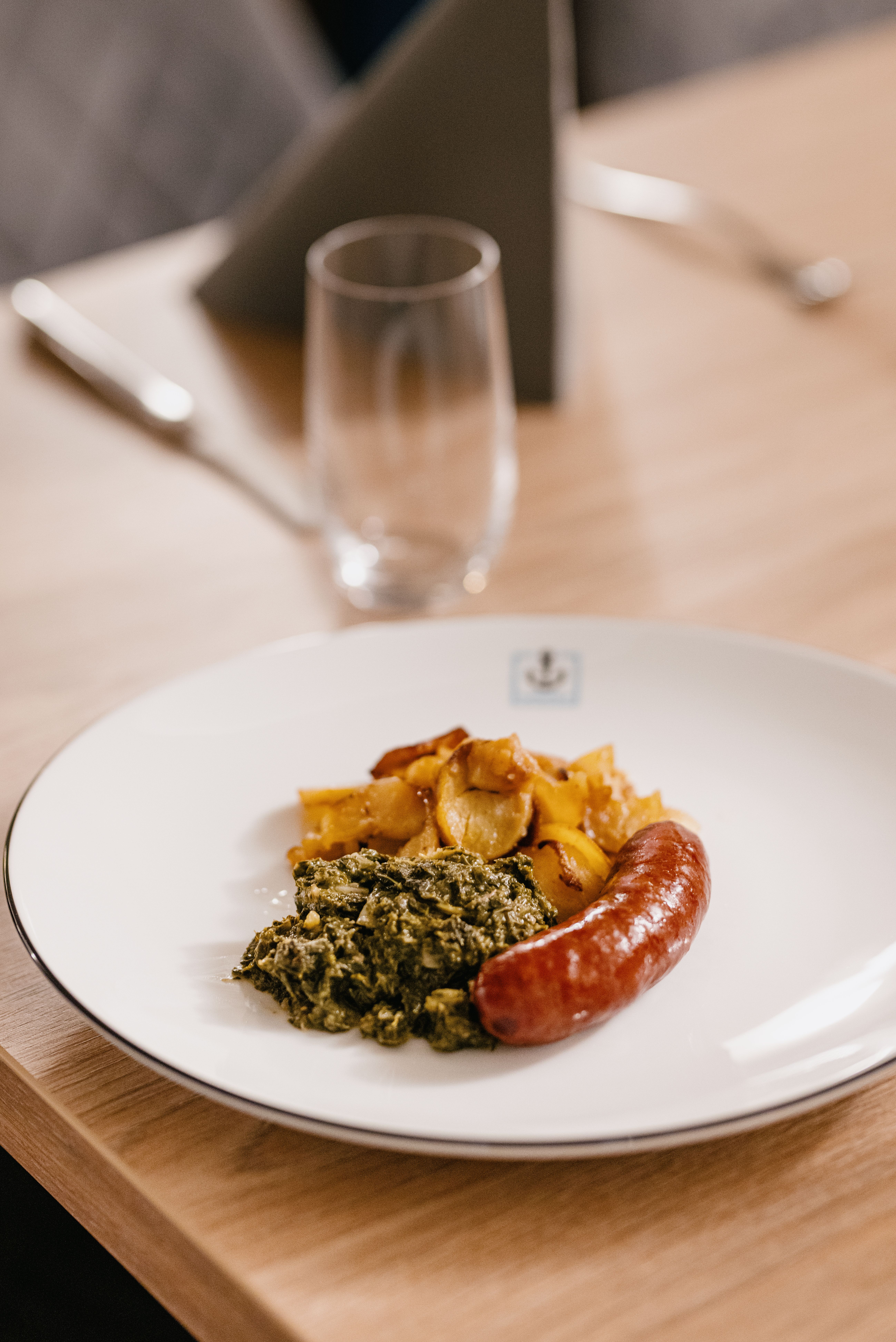 Ein Teller mit Grühnkohl, Wurst und Kartoffeln.