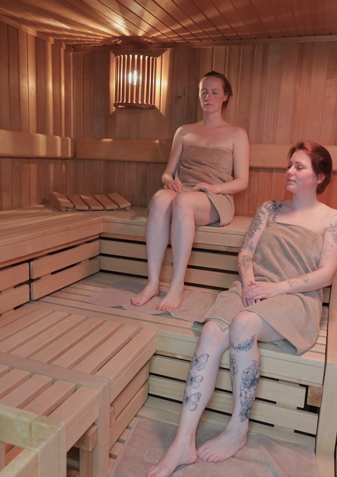 Zwei Frauen entspannen in einer Sauna.